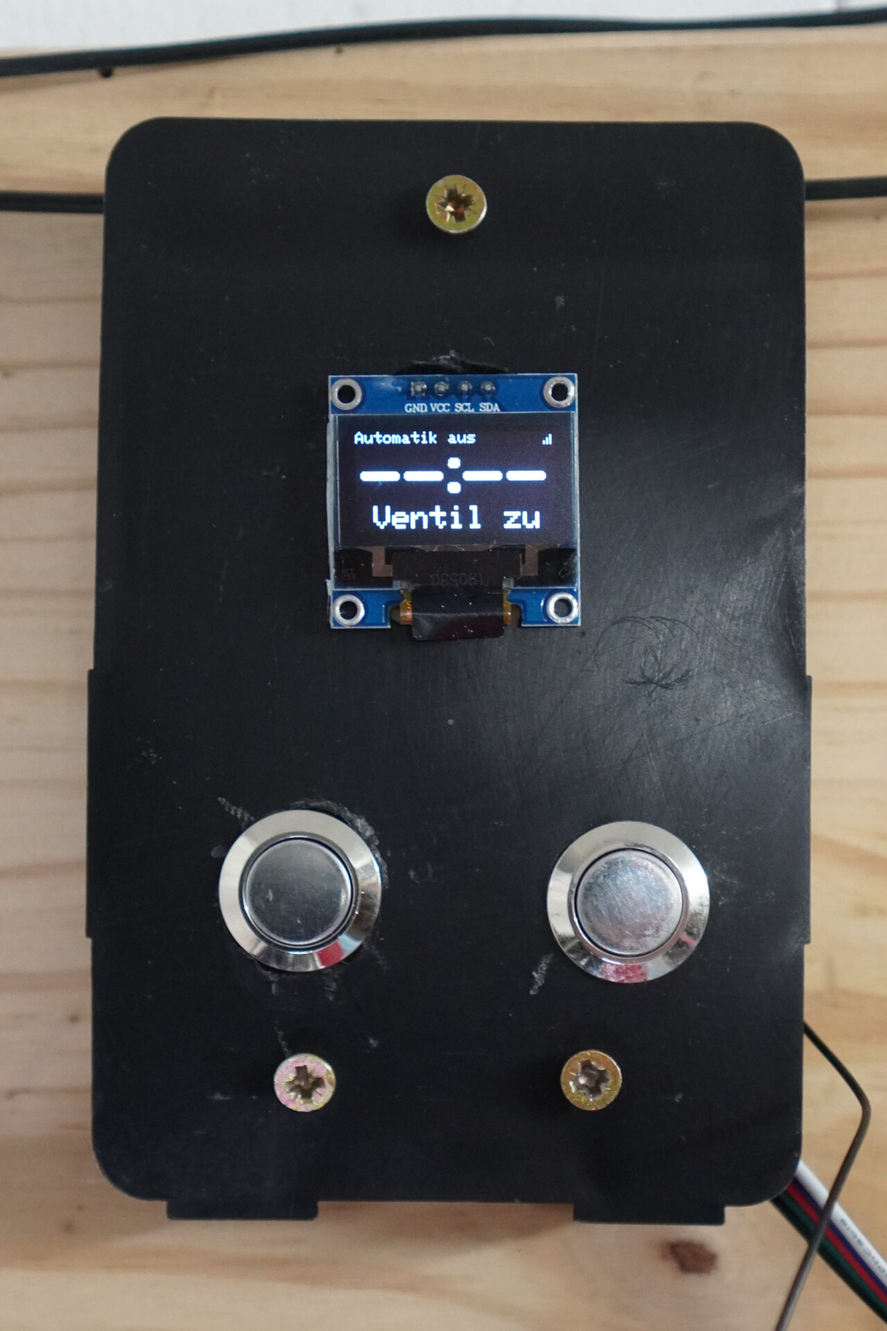 Photo of plastic piece with a small OLED screen and two buttons.