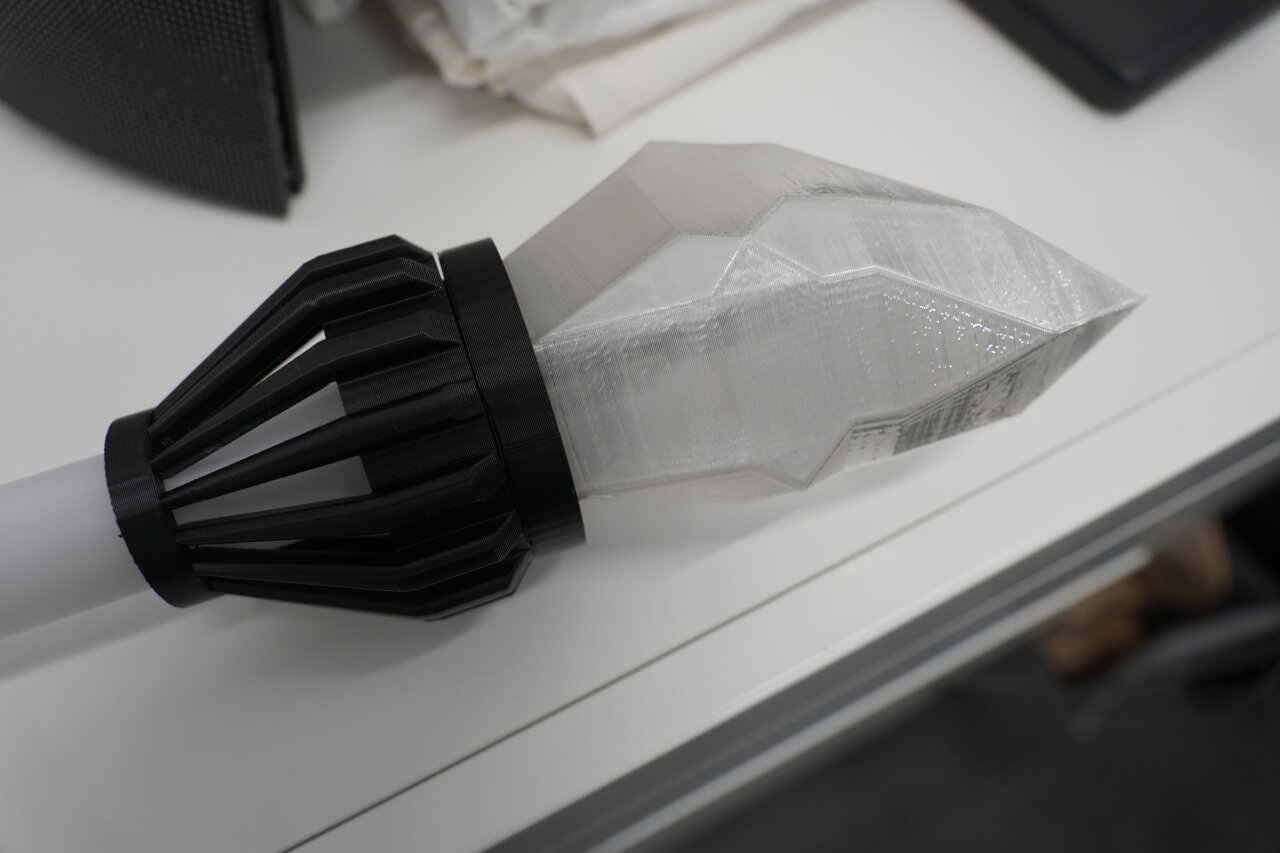 Photo of the assembled top part of the staff. A conical black part that connects the diffusor tube to a wider plate on which the transparent crystal is mounted.